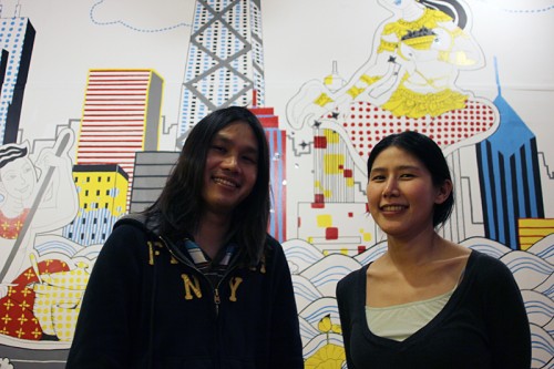 Dew Suriyawan and Noon Tosakulwong, in front of a wall depicting Thai food coming to Chicago