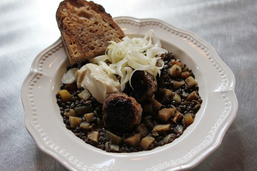 Sausage and lentils, topped with aioli and sautéed leeks.